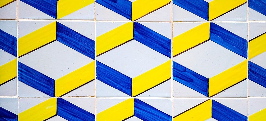 White kitchen tiles with blue and yellow zig zag patterns.
