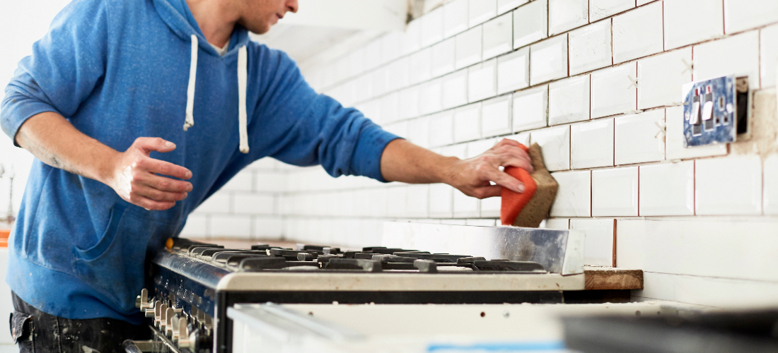 Worker applying finishing touches to tiles