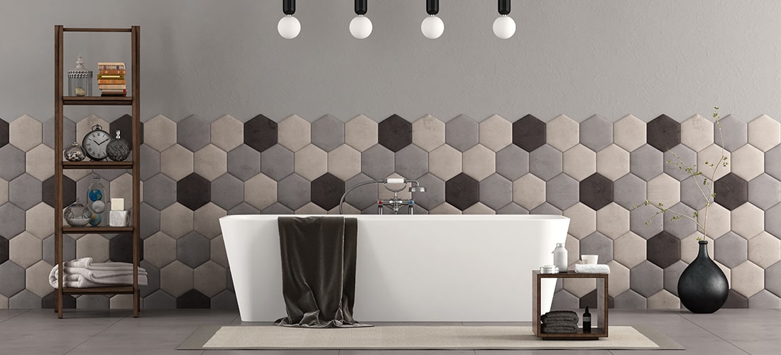 Luxury freestanding bathtub in front of tiled back wall with hexagon pattern.