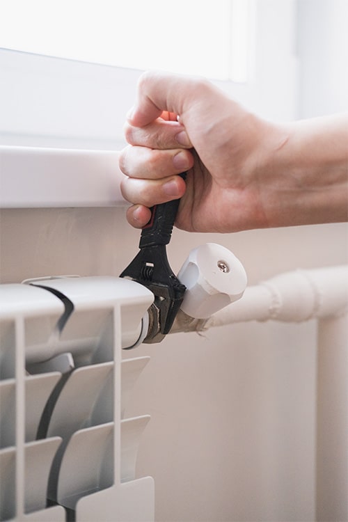 Engineer repairing broken radiator valve.