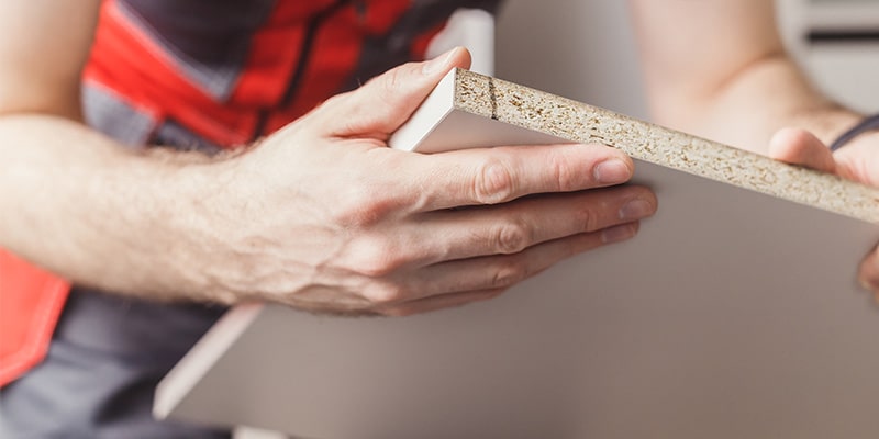 Worker inspecting chipboard.