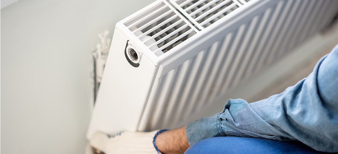 Heating engineer installing radiator.