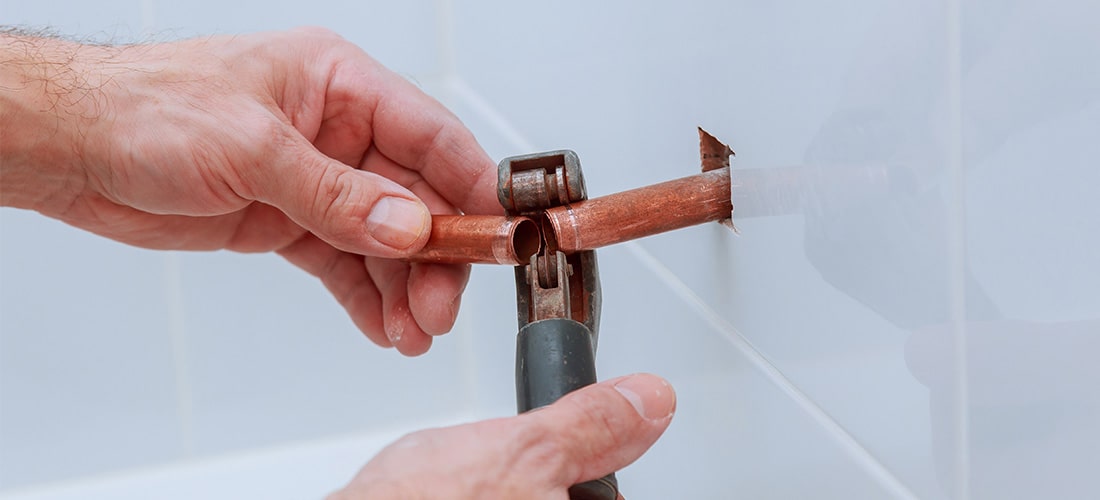 Plumber cutting copper pipe.