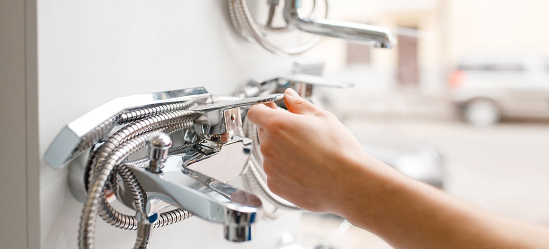 Plumber testing water on bath taps.