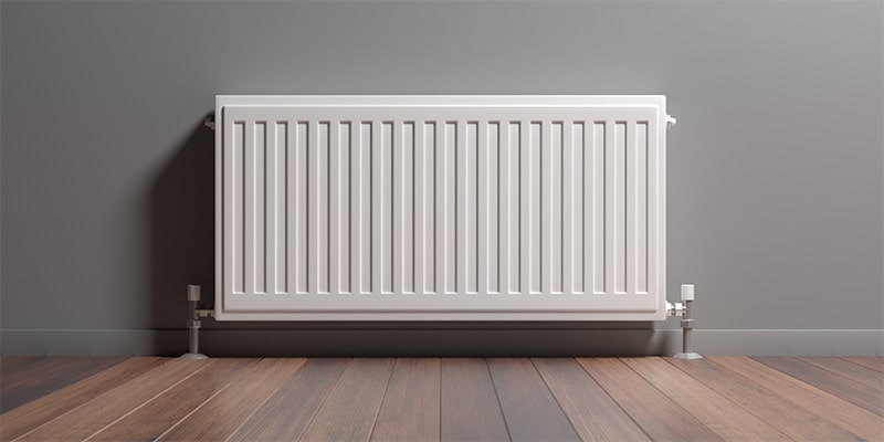 Classic column radiator against a grey wall.