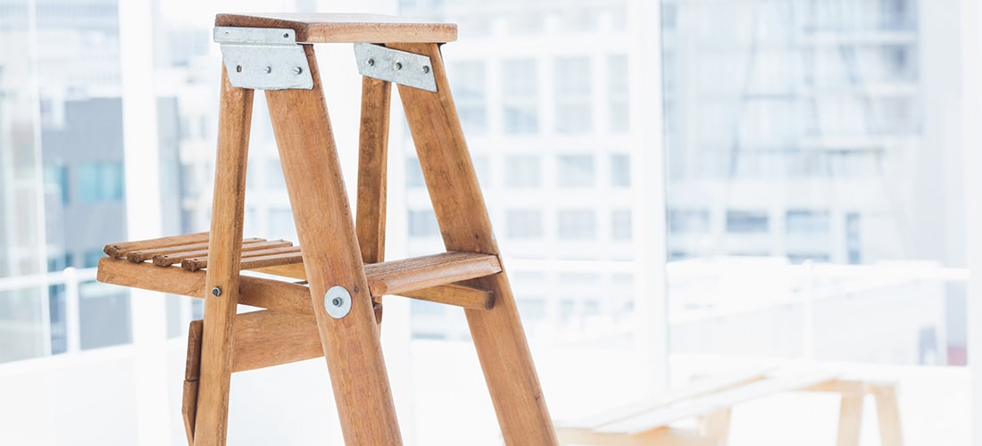 Wooden stepladder secured with metal brackets.