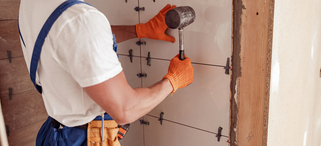 Worker checking tiles are fitted correctly