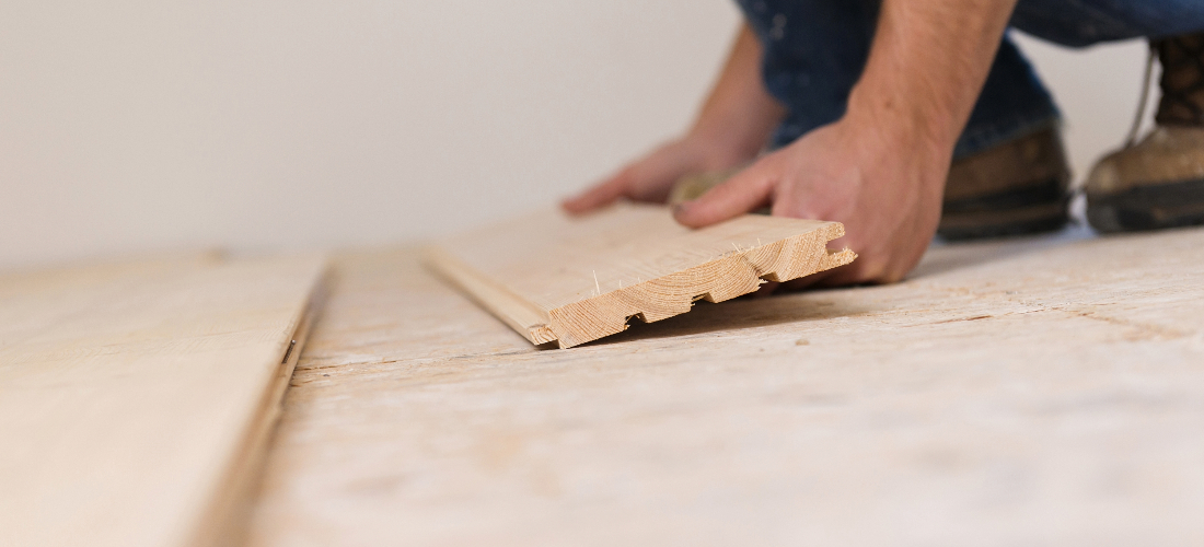 Worker laying wooden flooring